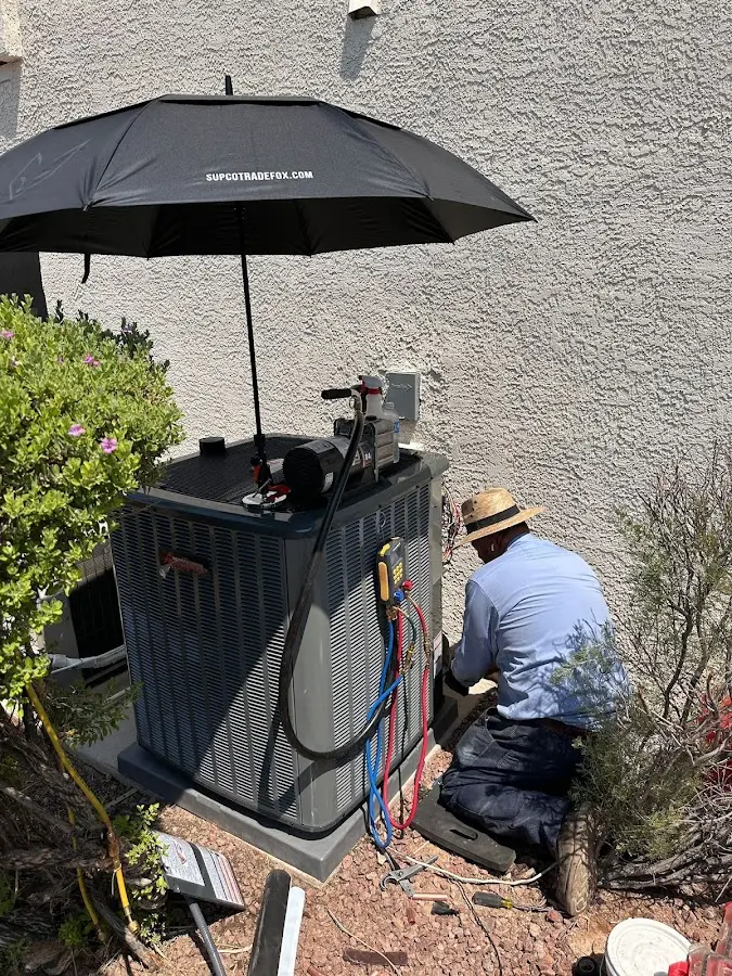 HVAC technician performing outdoor AC maintenance in Ozark